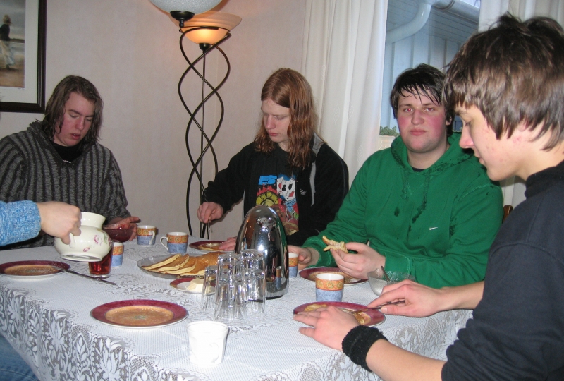 fire unge menn rundt bordet